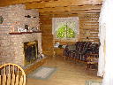 View of living room and fireplace on the main floor of Alpine Snow Cabin.